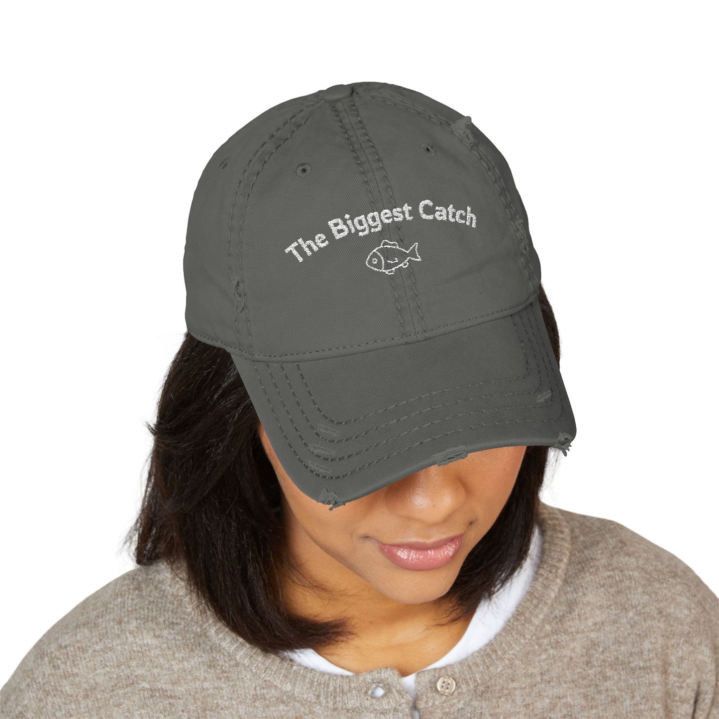 Person wearing a gray cap with 'The Biggest Catch' text and fish icon on a white background