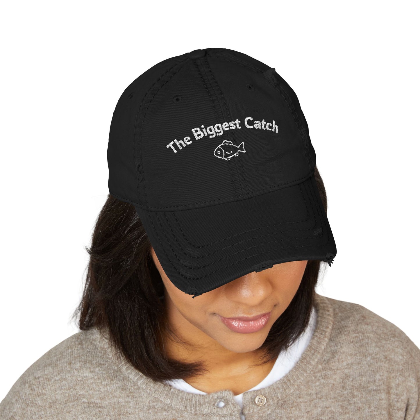 Black cap with 'The Biggest Catch' text worn by a person on a white background